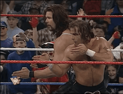 Two Men Wrestling in Ring With Crowd