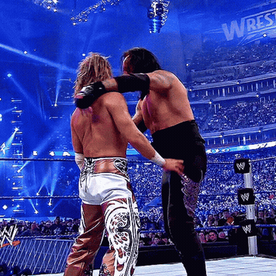 Two Men Wrestling In Ring With Wrestlemania Sign GIF
