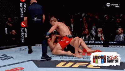 Two Men Wrestling In UFC Ring With 2 Shots In Every Can GIF
