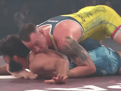 Two Men Wrestling One In Yellow Tank Top With Infinity GIF