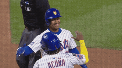 Two Mets Baseball Players Wearing Blue Helmets Are Smiling GIF