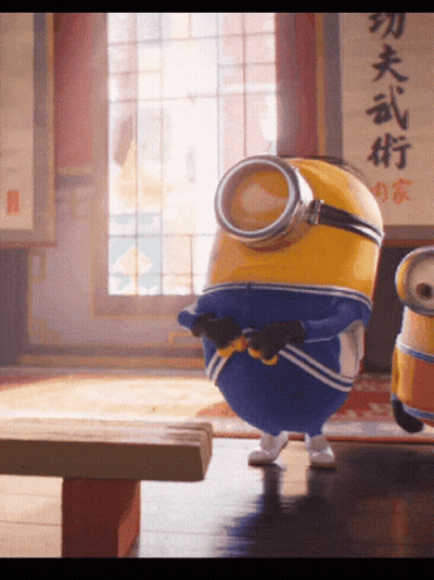 Two Minions Are Standing In Front Of A Sign With Chinese Writing On It GIF