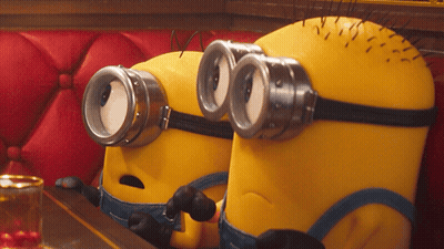 Two Minions Wearing Goggles On Red Couch GIF