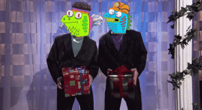 Two Monsters In Suits Are Holding Presents In Front Of A Curtain GIF