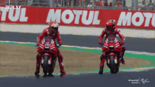 Two Motorcycle Racers On Track With Motul Sign GIF