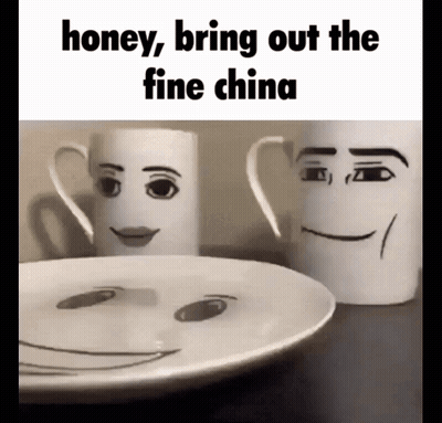Two Mugs With Faces Drawn On Them Are Sitting Next To A Plate GIF