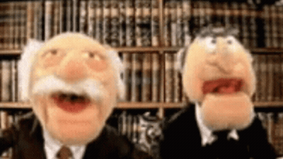 Two Muppets Standing In Front Of Bookshelf GIF