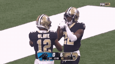 Two New Orleans Saints Football Players High Five Each Other On The Field GIF
