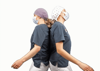 Two Nurses In Scrubs And Masks Dancing GIF