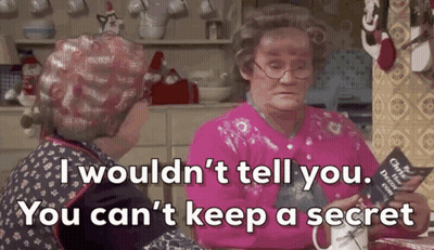 Two Older Women Are Sitting At A Table In A Kitchen Talking To Each Other And One Of Them Is Holding A Book . GIF