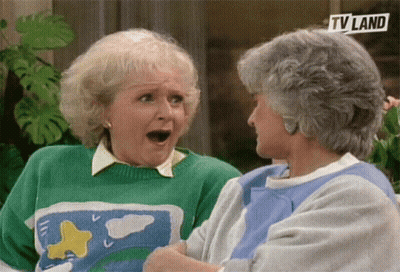 Two Older Women Are Sitting Next To Each Other And One Is Wearing A Green Sweater And The Other Is Wearing A Blue Shirt  GIF