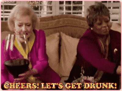 Two Older Women Drinking Wine And Dancing On Couch GIF