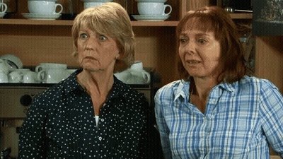 Two Older Women Standing By Coffee Machine GIF