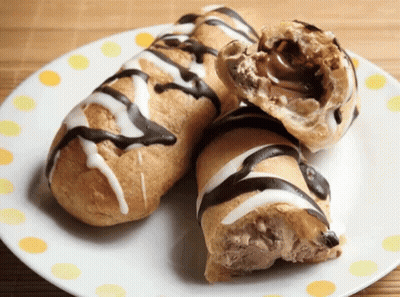 Two Pastry Rolls With Chocolate And Icing On A Plate GIF