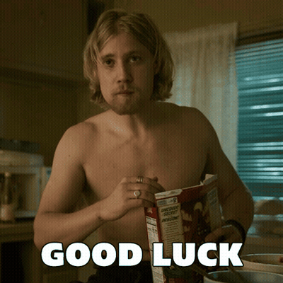 Two Penguins Holding Four Leaf Clovers Saying Good Luck GIF