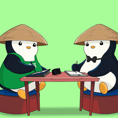 Two Penguins Sitting At Table One Wearing Green Shirt Saying Ice GIF