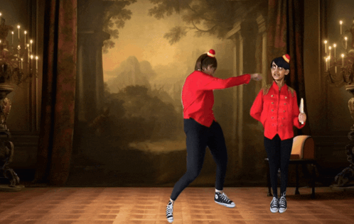 Two People Are Dancing In Front Of A Painting On The Wall GIF