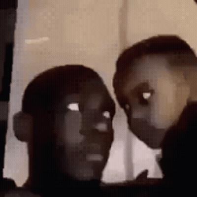 Two People Are Looking At Each Other Through A Window . GIF