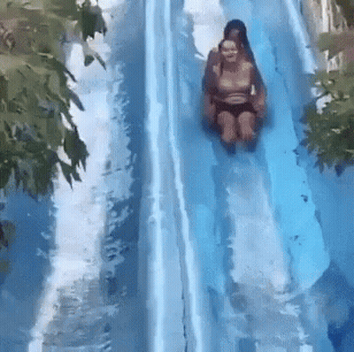 Two People Are Riding Down A Water Slide At A Water Park GIF