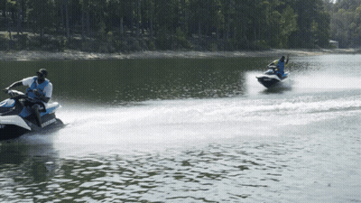 Two People Are Riding Jet Skis On A Lake And One Of The Jet Skis Has The Word Sea Doo On It GIF