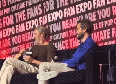 Two People Are Sitting In Front Of A Wall That Says " Are You Ready " On It GIF