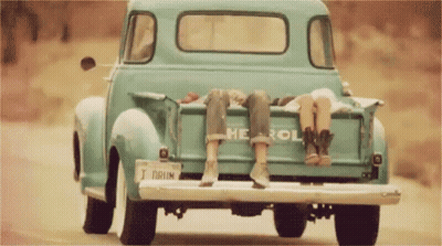 Two People Are Sitting In The Back Of A Blue Chevrolet Truck GIF