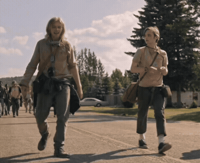 Two People Are Walking Down A Street And One Has A Purse Around Her Shoulder GIF