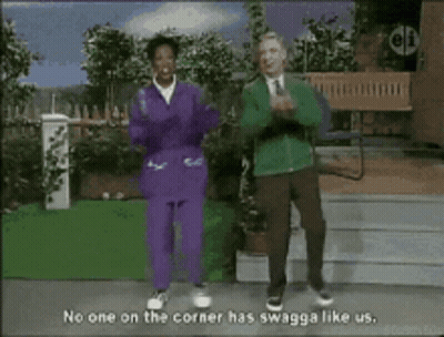Two People Dancing In Front Of No One On The Corner Has Swagga Like Us Sign GIF