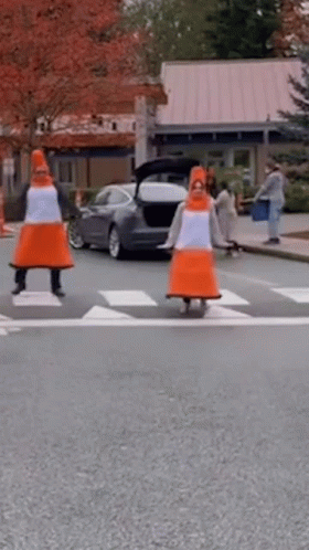 Two People Dressed As Traffic Cones Crossing Street GIF