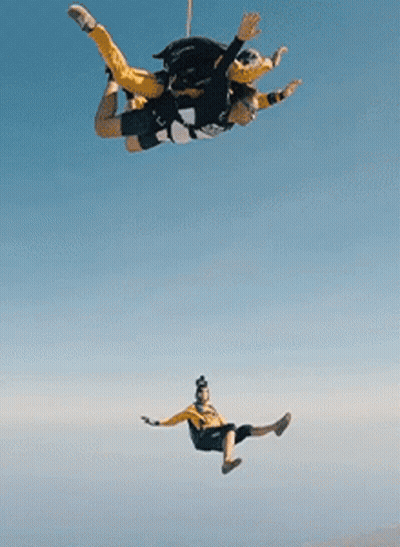 Two People Flying With Parachute GIF