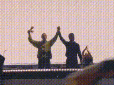 Two People High-Fiving On Stage In Front Of Crowd GIF