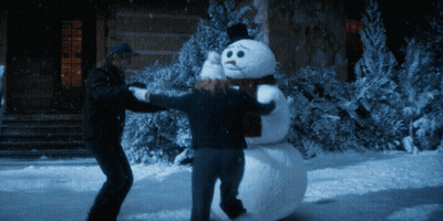 Two People Holding Snowman With Scarf GIF