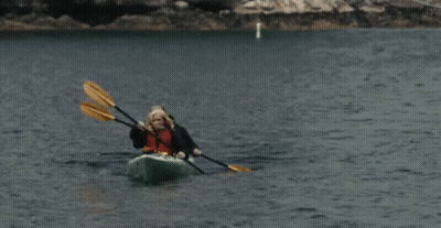Two People In A Kayak With Yellow Paddles In The Water GIF