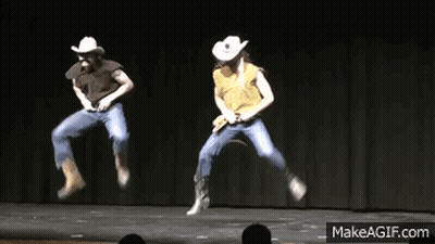 Two People In Cowboy Hats Are Jumping In The Air On Stage GIF
