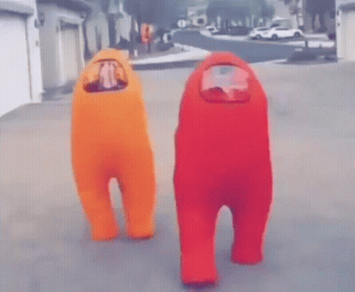 Two People In Orange And Red Among Us Costumes Standing On Street GIF