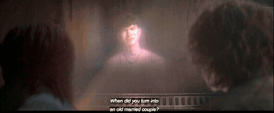 Two People Looking at Projection of Woman Saying When Did You Turn Into an Old Married Couple