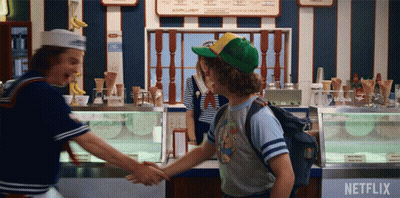 Two People Shake Hands In Front Of Netflix Advertisement GIF
