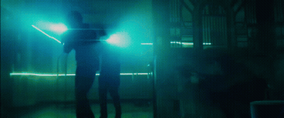 Two People Standing In A Dark Room With Blue Lights GIF