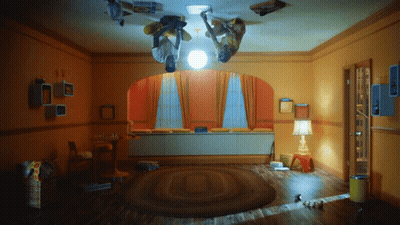 Two People Upside Down In Room With Lamp And Box Saying A GIF