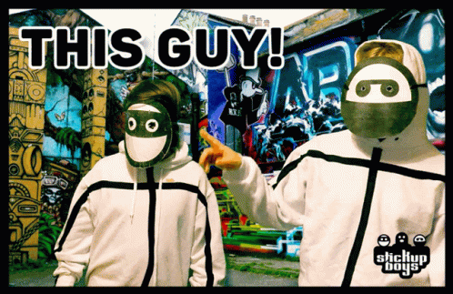 Two People Wearing Masks Are Standing In Front Of A Wall That Says This Guy ! GIF