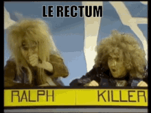 Two People With Sign Saying Le Rectum Ralph Killer GIF