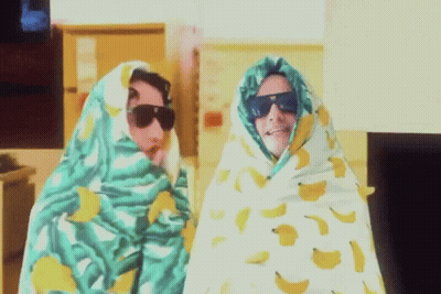 Two People Wrapped In Banana Blanket With Sunglasses GIF