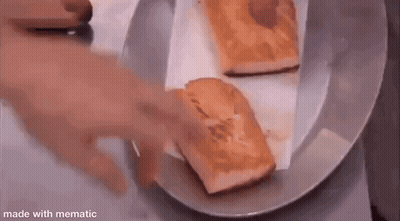 Two Pieces Of Bread Are Sitting On A Plate On A Table . GIF