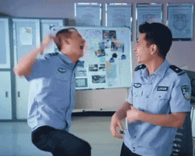 Two Police Officers Are Dancing In Front Of A White Board With Pictures GIF