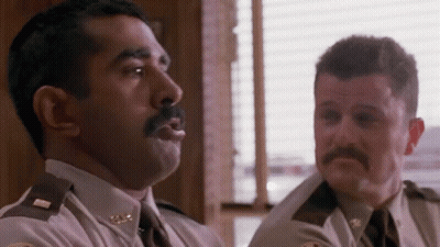 Two Police Officers Are Sitting Next To Each Other In A Room And Talking To Each Other . GIF