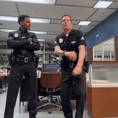 Two Police Officers Dancing In Office With L.A. Badge GIF