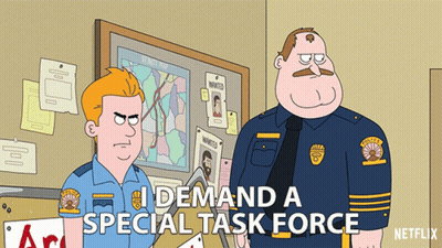 Two Police Officers Standing In Front Of Bulletin Board Saying I Demand A Special Task Force GIF