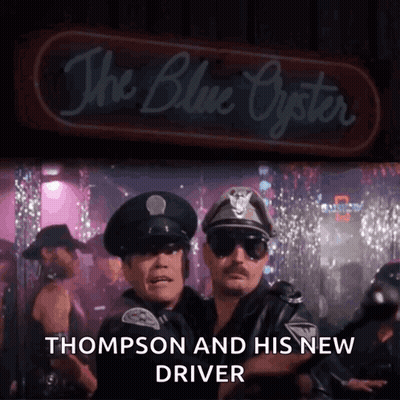 Two Police Officers Standing In Front Of The Blue Oyster GIF