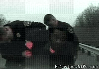 Two Police Officers Standing Together With Hilariousgifs.com Watermark GIF