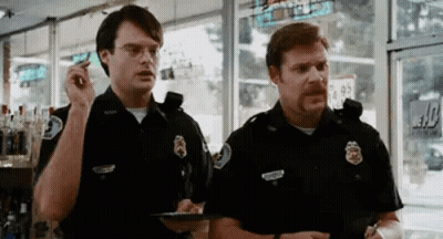 Two Police Officers Talking In Store GIF